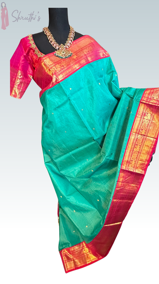 Close-up of pink and teal Kanchi pattu saree pallu with intricate silver zari pattern and fine handwoven detailing.
