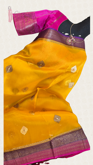 Lightweight transparent Banaras organza silk saree in yellow pink shade with gold zari and lined blouse, perfect for party wear.