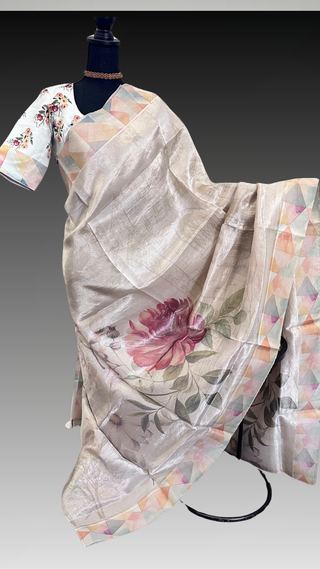 Cream floral organza tissue silk saree with pastel geometric border displayed on mannequin