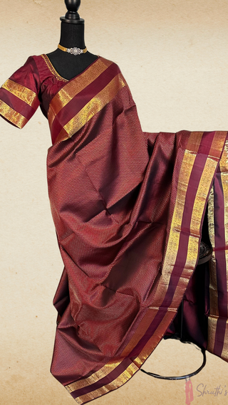 Elegant dark burgundy Kanjivaram silk saree with pure gold zari and hand-embroidered prestitched blouse, ideal for weddings and festive wear.