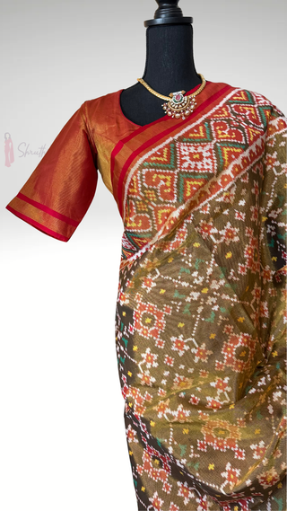 Handwoven dark olive green tissue Patan Patola silk saree featuring double ikat design, silk finish gold zari pallu, and pre-stitched blouse, crafted by expert weavers for a premium bridal look.