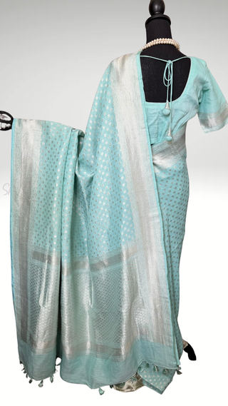 Elegant pastel cyan linen saree with shimmering silver zari border and soft drape