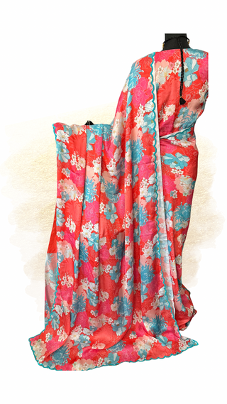 Floral pink satin silk saree displayed on a mannequin with matching stitched blouse and scallop embroidered border.