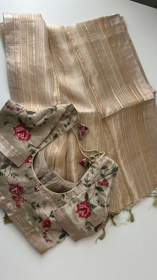 Beige gold organza tissue saree featuring fine texture and embroidered borders.