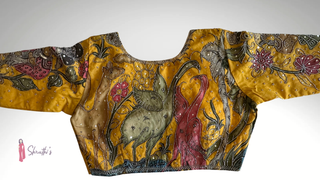 Yellow cotton Kalamkari blouse featuring hand-painted traditional artwork and embroidery.