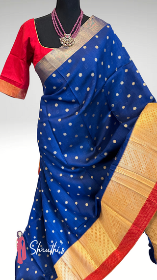 Partywear silk saree with golden polka motifs and red edging.