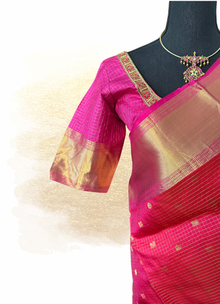 Traditional pinkish red Kanjivaram pattu saree with gold zari border and classic handwoven texture.