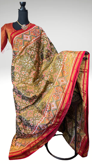 Elegant olive green Patola silk saree in tissue weave with intricate patterns, rich gold pallu, and prestitched blouse, ideal for weddings and festive wear.