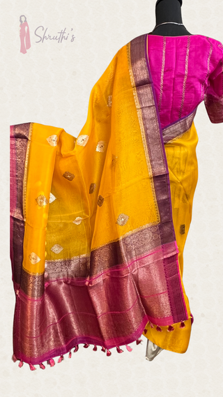 Dual-tone yellow and pink Banaras organza saree featuring fine handloom weave, pure zari detailing, and prestitched blouse.