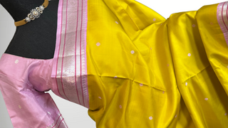 Elegant pastel pink and yellow Kanchipuram silk saree with hand-embroidered blouse and intricate silver zari weave.
