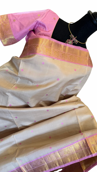Soft pastel pure silk Ven Pattu saree handwoven in Kanjivaram style with silver zari pallu and hand-embroidered blouse stitched up to size 42.