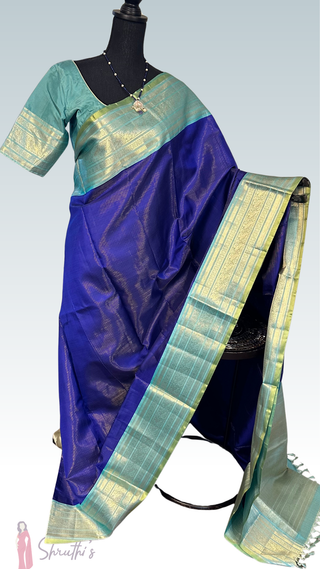 Authentic handwoven Kanchivaram silk saree in royal blue with silver zari, stitched blouse, lightweight drape, ideal for Indian weddings and festive occasions.