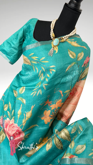 Elegant turquoise silk saree with colorful nature-inspired motifs