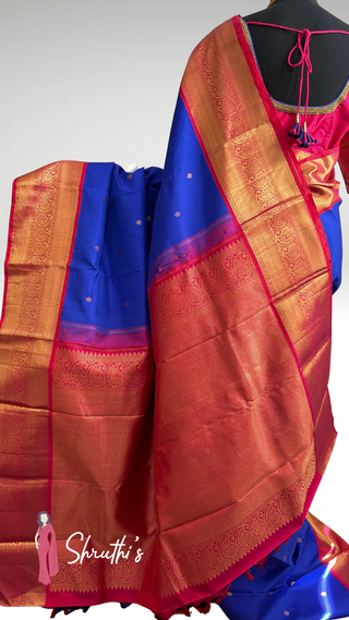 Pure silk saree in rich blue and pink paired with an embroidered blouse.
